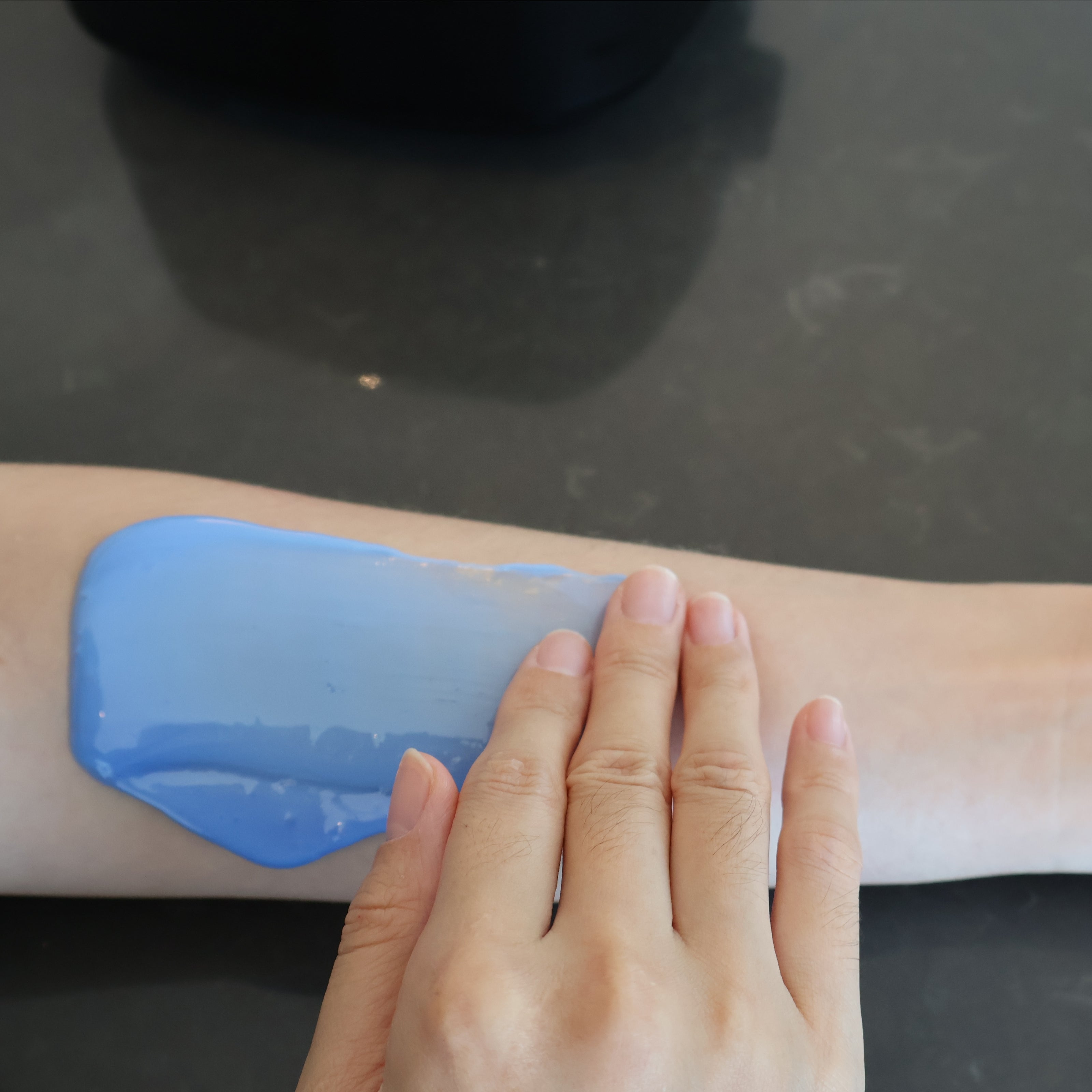 Pressing Lumixsilva hard wax on arm to check readiness before removal during at-home waxing